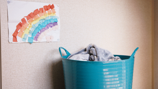 A washing basket is filled to the top with clothes