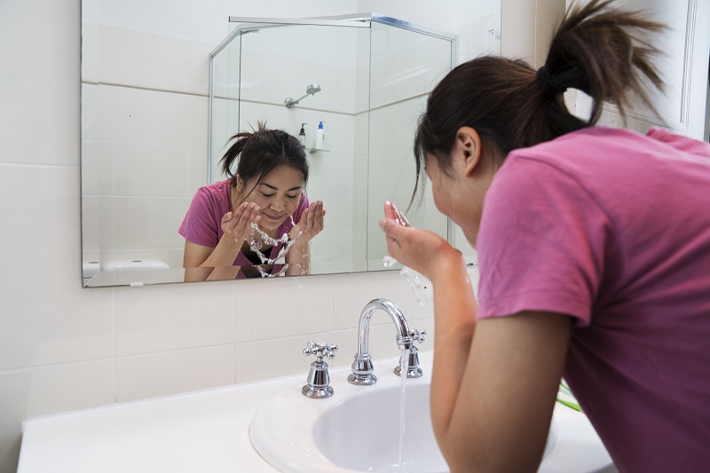 Girl washing her face.