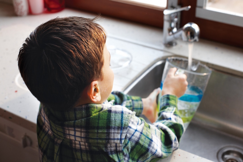 Boy filling up jug from tap